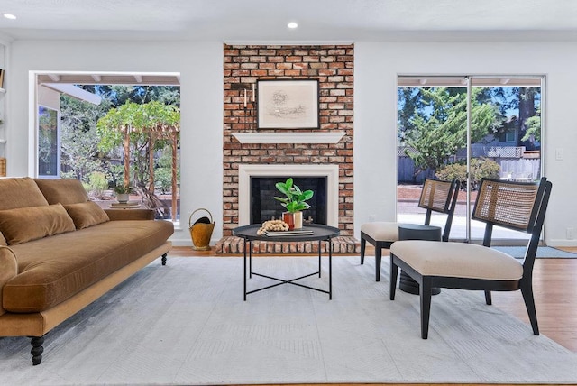 living room with a brick fireplace and light hardwood / wood-style floors