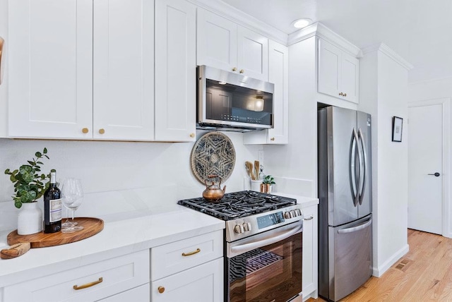 kitchen featuring appliances with stainless steel finishes, white cabinets, and light hardwood / wood-style flooring