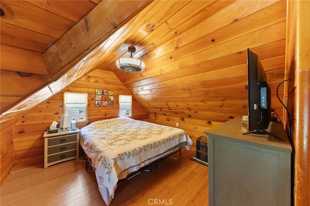 bedroom featuring hardwood / wood-style floors, wooden walls, wooden ceiling, and vaulted ceiling