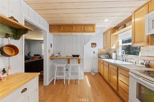 kitchen featuring white appliances, tasteful backsplash, sink, light hardwood / wood-style floors, and wooden ceiling