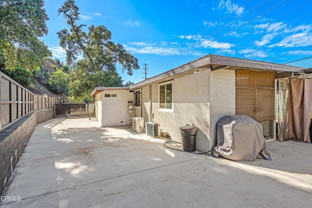 rear view of property with central AC unit and a patio area