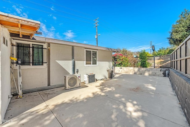 view of side of property featuring a patio and ac unit