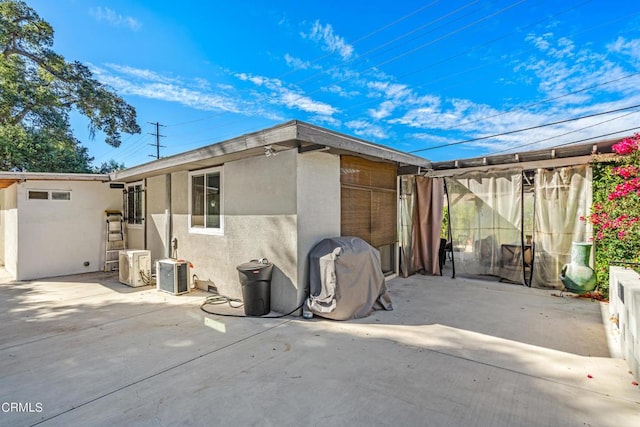 back of property featuring cooling unit and a patio area