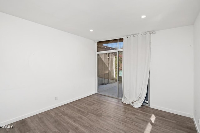 empty room with floor to ceiling windows and dark hardwood / wood-style floors