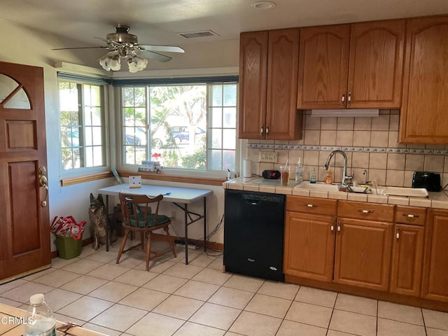 kitchen with tile countertops, ceiling fan, light tile patterned floors, and black dishwasher