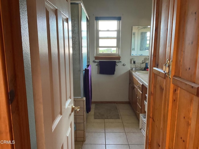 bathroom with tile patterned flooring, vanity, and a shower