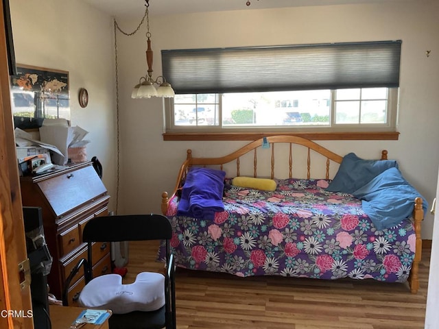 bedroom with hardwood / wood-style floors and multiple windows