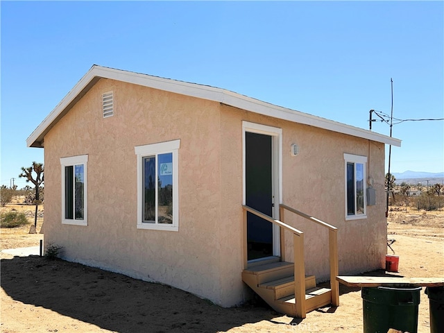 back of property with entry steps and stucco siding