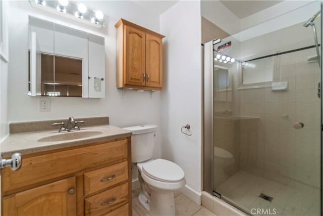 bathroom featuring tile patterned flooring, vanity, toilet, and walk in shower