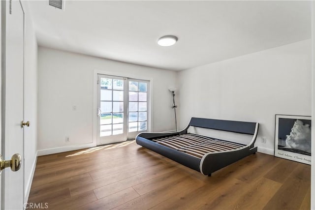 bedroom featuring dark hardwood / wood-style floors and access to outside