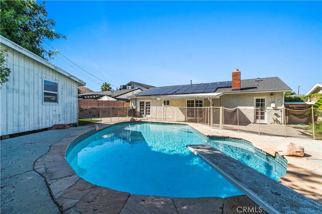 view of pool with french doors and a patio area