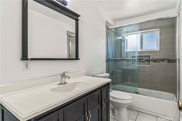 full bathroom with tile patterned flooring, vanity, bath / shower combo with glass door, and toilet