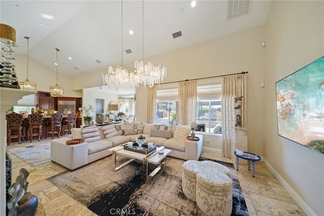 living room featuring a chandelier and high vaulted ceiling