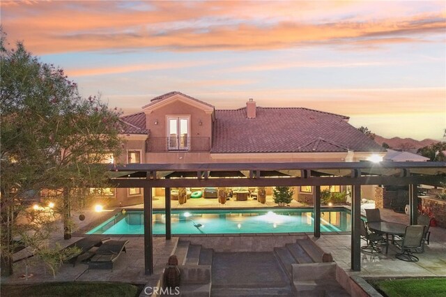 pool at dusk with a patio