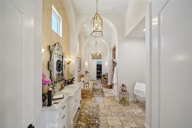 hallway with a notable chandelier and sink