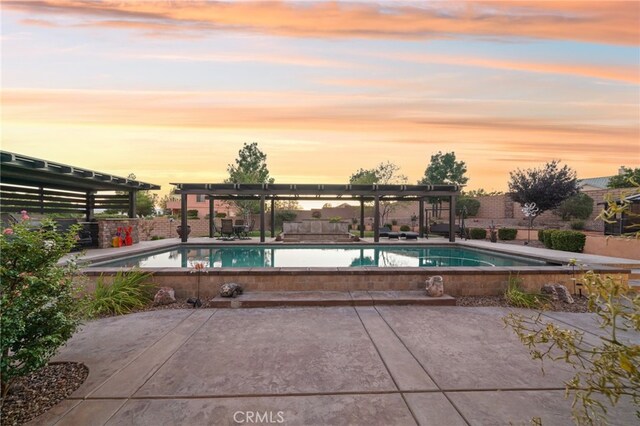 pool at dusk featuring a patio area and a pergola