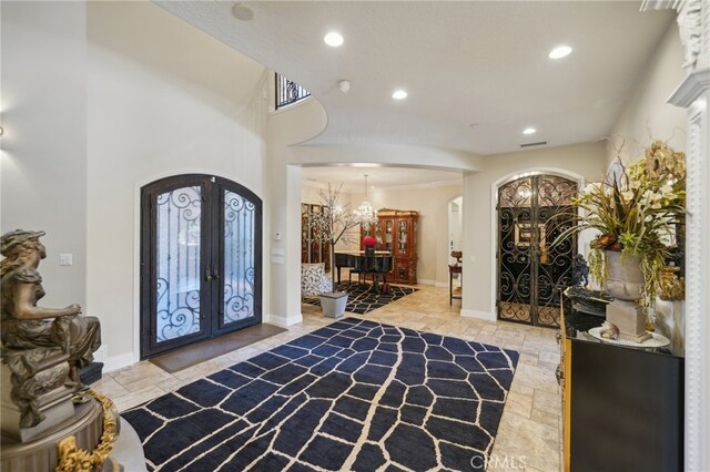 foyer entrance with french doors, an inviting chandelier, and plenty of natural light