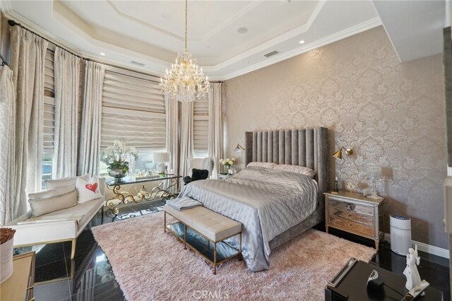 bedroom with ornamental molding, a notable chandelier, and a tray ceiling