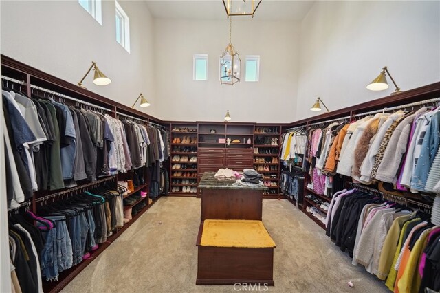 walk in closet featuring a high ceiling and light colored carpet