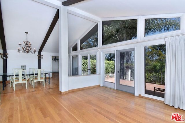 interior space with beamed ceiling, light wood-type flooring, and plenty of natural light