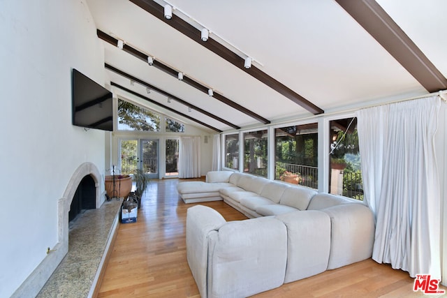 living room featuring a premium fireplace, beamed ceiling, high vaulted ceiling, track lighting, and light wood-type flooring