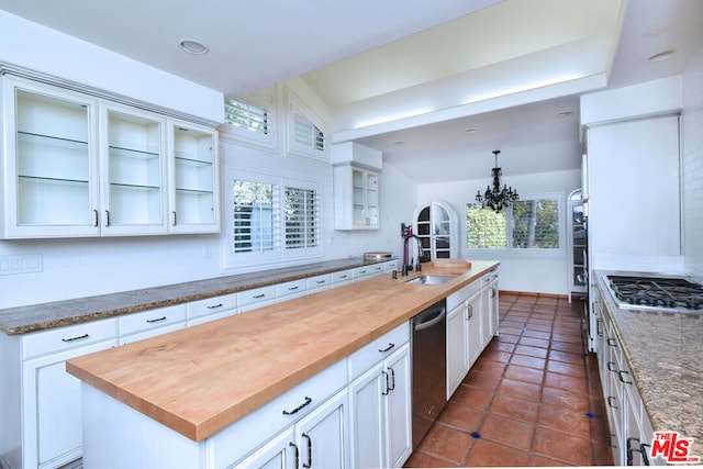 kitchen featuring a center island with sink, butcher block countertops, a healthy amount of sunlight, and sink