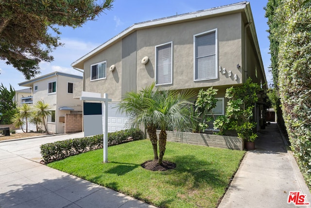 view of front of property with a front lawn and a garage