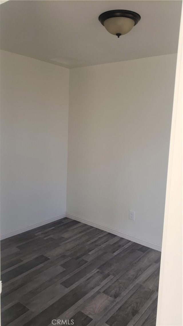 spare room featuring dark wood-type flooring