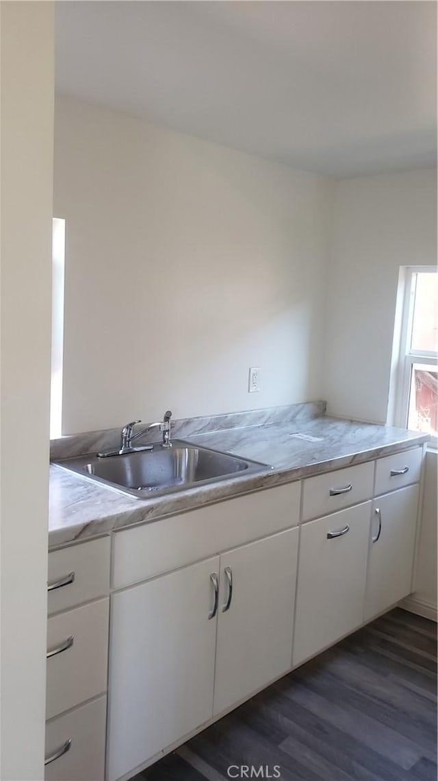 kitchen featuring dark hardwood / wood-style flooring, sink, and white cabinets