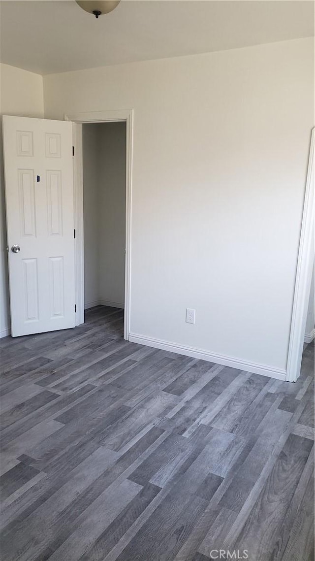 unfurnished bedroom featuring dark hardwood / wood-style flooring and a closet