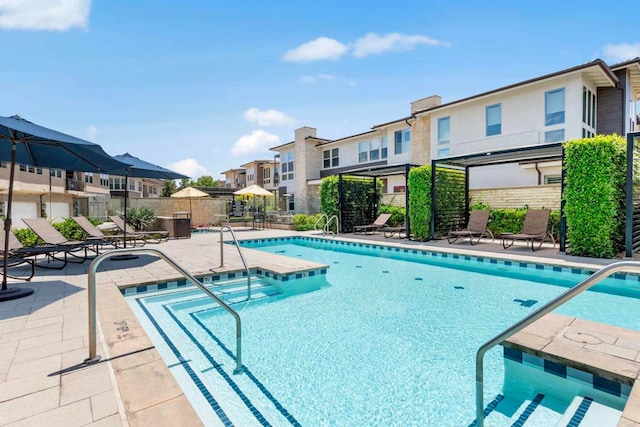 view of swimming pool with a patio and a hot tub