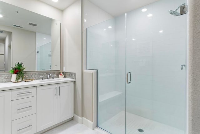 bathroom with vanity, an enclosed shower, and decorative backsplash