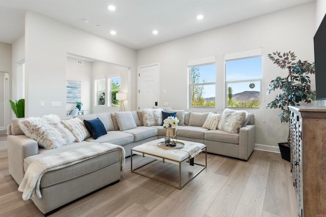 living room with light hardwood / wood-style flooring and a healthy amount of sunlight