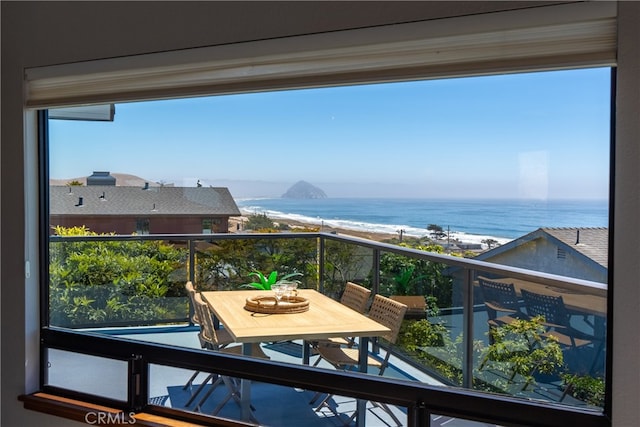 balcony with a water view and a view of the beach