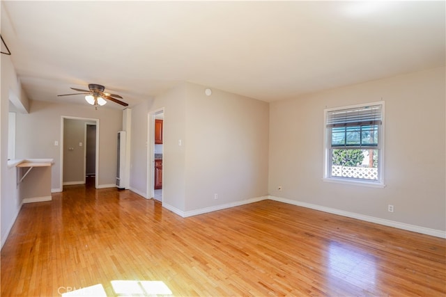 unfurnished room with light wood-type flooring and ceiling fan