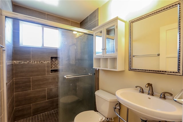 bathroom with toilet, sink, and an enclosed shower