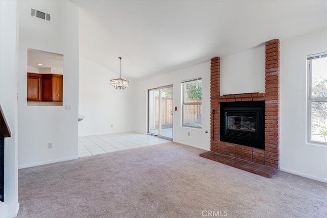 unfurnished living room with a fireplace, light carpet, and a notable chandelier