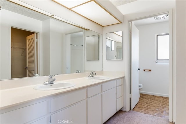 bathroom featuring vanity, toilet, and a healthy amount of sunlight