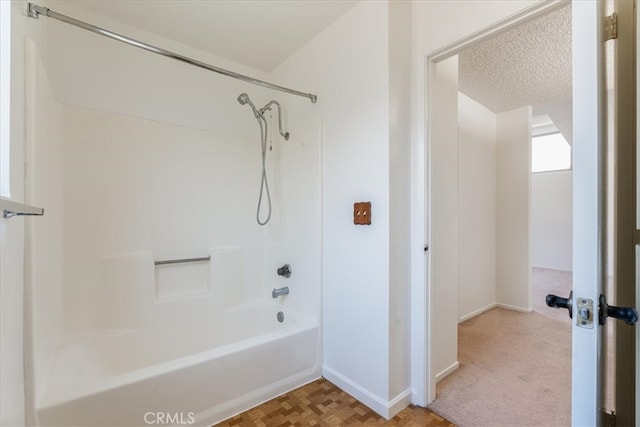 bathroom featuring a textured ceiling and shower / washtub combination