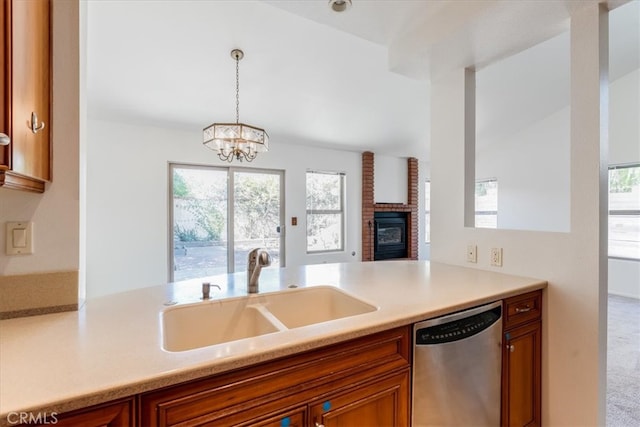 kitchen featuring pendant lighting, sink, carpet floors, an inviting chandelier, and stainless steel dishwasher