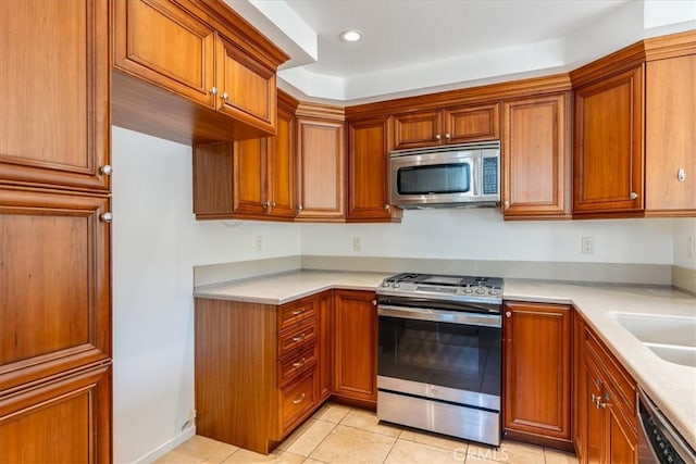 kitchen featuring appliances with stainless steel finishes, light tile patterned floors, and sink