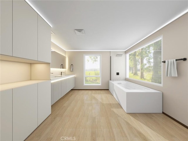 bathroom featuring hardwood / wood-style flooring, vanity, and a bath