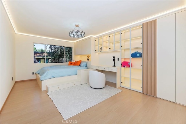 bedroom with a chandelier and light hardwood / wood-style floors