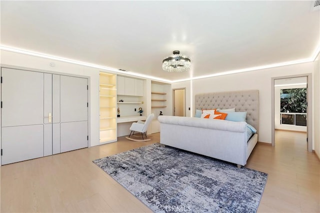 bedroom with light hardwood / wood-style floors and a chandelier