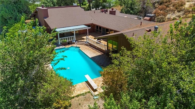 view of pool featuring a diving board and a deck