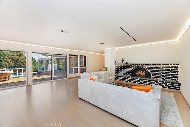 living room with wood-type flooring and a brick fireplace