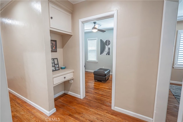 corridor with a healthy amount of sunlight and light hardwood / wood-style floors