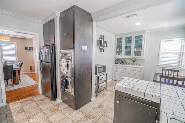 kitchen with light hardwood / wood-style flooring, stainless steel appliances, crown molding, and a wealth of natural light