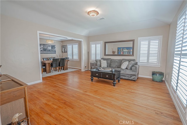 living room featuring vaulted ceiling, plenty of natural light, and hardwood / wood-style floors