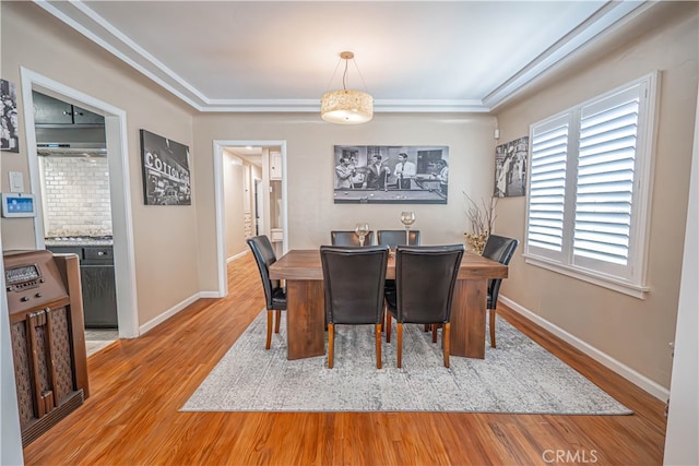 dining space with light hardwood / wood-style flooring and crown molding